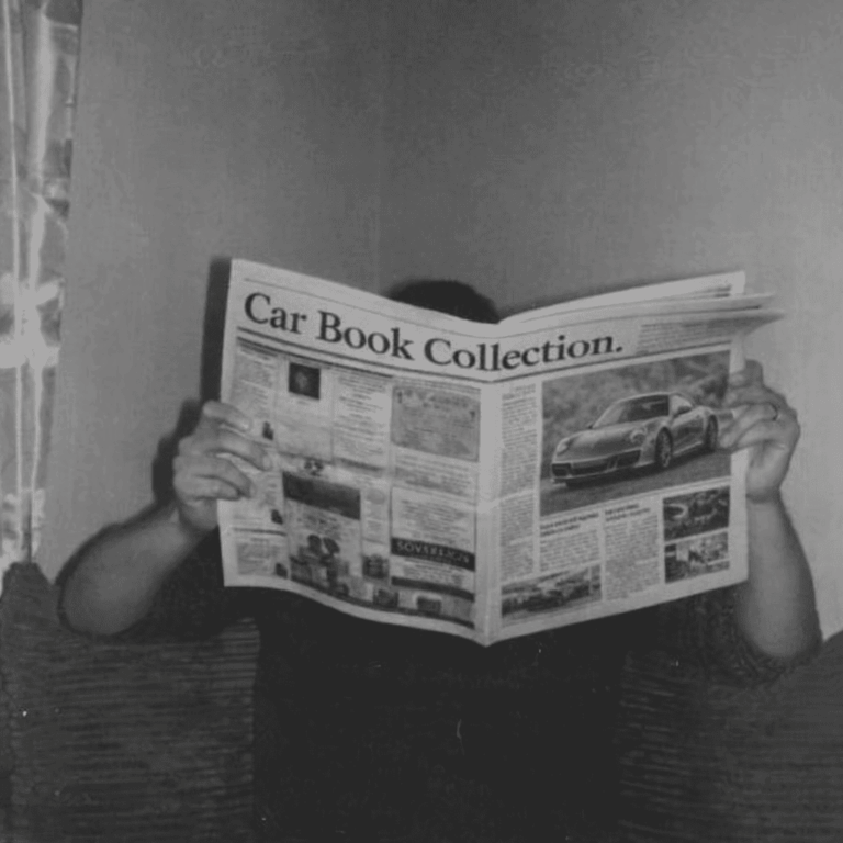 Personne lisant un journal intitulé car Book Collection